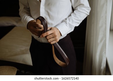 A Man Holds A Belt In His Hands. Man With Belt