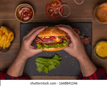 Der Mensch hält Burger mit Händen und Pommes frites und Taucher auf Hintergrund