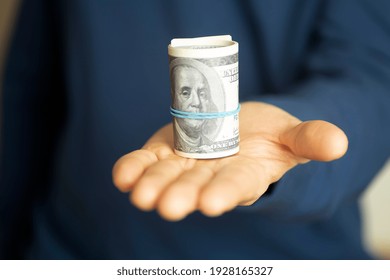 A Man Holds Cash American Dollars In His Hand. American Rescue Plan, USA Relief Program, Stimulus Check, Act Of 2021 Concept. Money, Business, Profit And Livelihood Idea