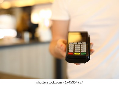 Man holds commercial portable banking terminal. To install wireless terminal for business. Convenient way to make settlements. Terminal payment by card. Effective acquiring offer - Shutterstock ID 1745354957