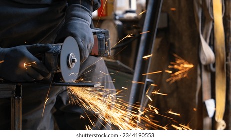 The man holds a flexi in his hands and cuts a metal plate - Shutterstock ID 2344190553