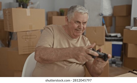 Man holds game controller with focused grip among stacked moving boxes and packing supplies in a building; concentration.