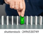 A man holds a green domino with a check mark. Checkpoint reached, milestone. Successfully completed. Ready for launch. Checking and verification. Start a business. A life stage that has been passed.