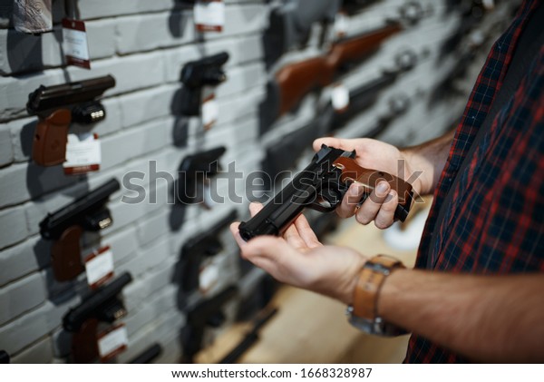 Man holds handgun in gun
shop