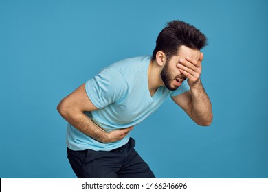      A Man Holds His Face His Stomach Abdominal Pain On A Blue Background                          