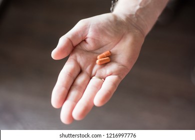man holds in his hand pills in capsules - Shutterstock ID 1216997776