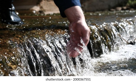 A Man Holds His Hand (washes His Hands) In The Fountain (water), Clearing Them Of Dirt, And Holding The Water Of The Waterfall In The Length Of His Hand. Concert Of: Feel The Water, Slow Motion.