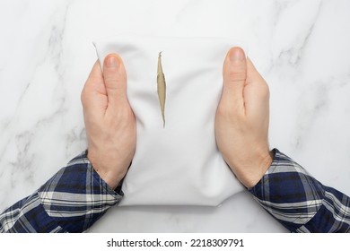 Man Holds A Leather Product With A Cut, A Hole In A White Leather Fabric. Top View. Marble Background