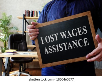 Man Holds Lost Wages Assistance Plate In The Office.