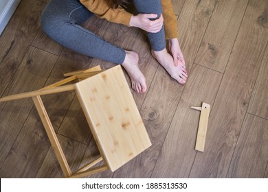 A Man Holds On To His Injured Leg After Falling From A Wooden Ladder. Safety Issues At Work At Height Due To Disruption To Work At Home