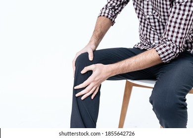 A man holds on to his knees and does a massage for pain. A man bruised his knee and tugged at him with both hands in pain.