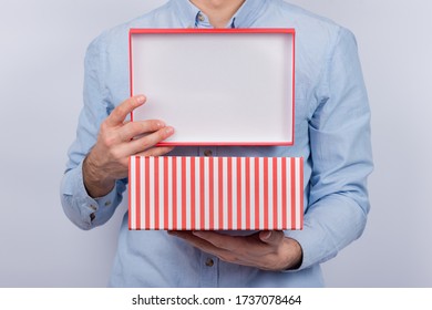 Man Holds Open The Festive Box. Gift Box In Men's Hands. Front View