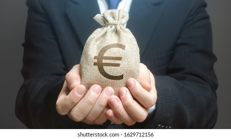 A man holds out a euro money bag. Granting financing business project or education. Provision cash financial loan credit. Investment. Bank deposit. Budget management, tax collection. Trade, economics. - Shutterstock ID 1629712156