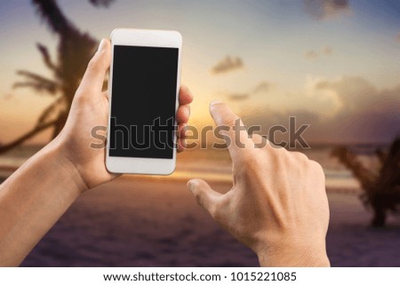 Man holds phone on the beach background