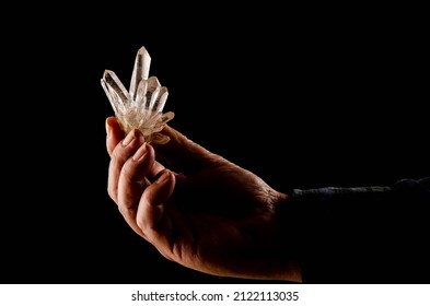 A Man Holds A Precious Formation Of Quartz Crystals On A Black Background. Quartz Is A Mineral Composed Of Silica. It Stands Out For Its Hardness And Resistance To Weathering On The Earth's Surface.