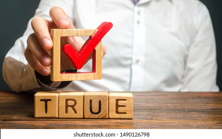 A man holds a red check mark over word True. Confirm the veracity and truth. Fight against fake news hostile propaganda. Confirmation facts, refutation of rumors. Debunking Myths and Misconceptions - Shutterstock ID 1490126798