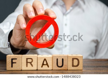 A man holds a red NO prohibition symbol over word fraud. Countering deception, protection against fraudsters. The fight corruption, financial pyramids and business scams. War on crime. Cheaters
