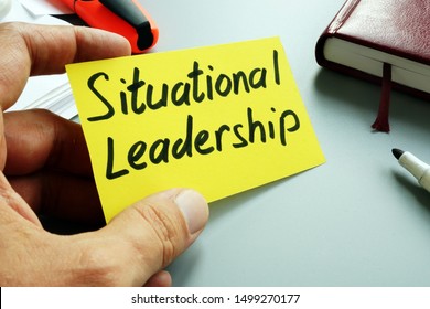 Man holds sign Situational Leadership on a yellow piece of paper. - Shutterstock ID 1499270177