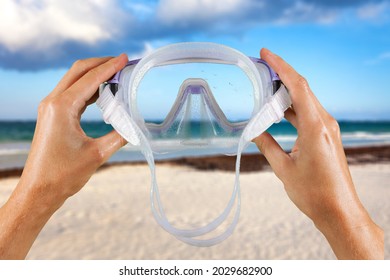 A Man Holds A Snorkel Mask In His Hand Against A Clear Blue Sky Background