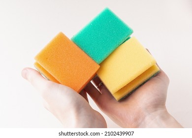 Man holds sponges for washing dishes. Set of colorful sponges