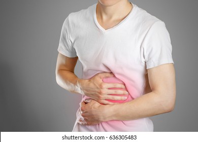 A man holds the stomach. The pain in his chest. Heartburn. Stomach hurts. Sore point highlighted in red. Closeup. Isolated.