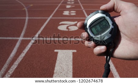 Man holds stopwatch with time ten seconds, world record, victory in competition