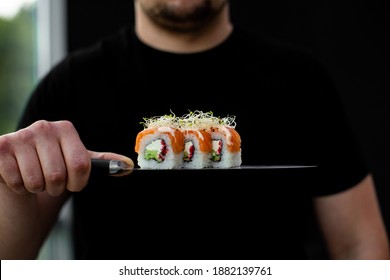 
Man Holds Sushi On The Knife