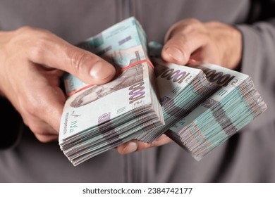 Man holds two bundles of hryvnia in her hand. Ukrainian money. Business concept. 1000 hryvnia banknotes.