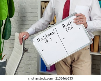 Man Holds Whiteboard With Pros And Cons For Traditional And Roth IRA.