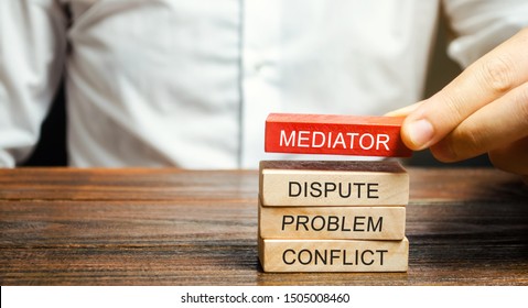A man holds wooden blocks with the word Mediator, dispute, problem, conflict. Settlement of disputes by mediator. Dispute Resolution and Mediation. Third party, intermediary. - Shutterstock ID 1505008460