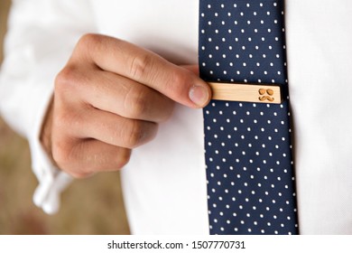 Man Holing Gold Tie Clip