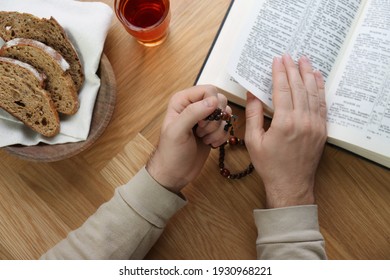 Man With Holy Bible, Prayer Beads, Bread And Drink At Wooden Table, Top View. Great Lent Season