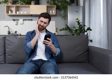 A Man At Home Has A Severe Toothache, Tries To Call A Doctor And Consult Online, Uses The Phone And Medical Application