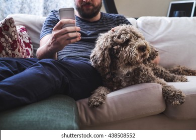 Man at home with a tablet and a dog