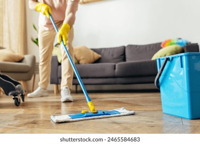 Man in homewear deep-cleaning floor with a mop. - Powered by Shutterstock