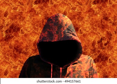 Man with a hoodie walking through the fire devil halloween concept