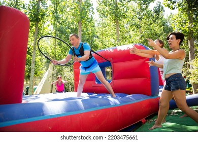 Man With Hoop Playing Tug Of War Game With Opponent. People Having Fun In Outdoor Adventure Park.