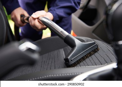Man Hoovering Seat Of Car During Car Cleaning