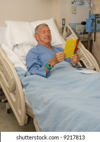 Man In Hospital Bed Reading A Get Well Card