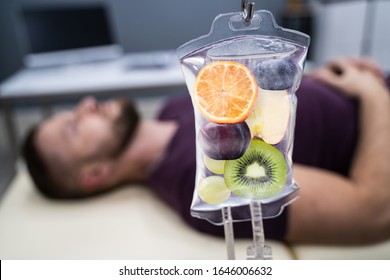 Man In In Hospital Getting IV Infusion Of Fruit Slices Inside Saline Bag 