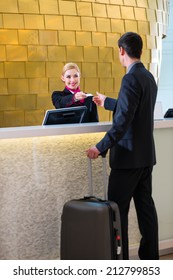 Man In Hotel Check In At Reception Or Front Office Being Given Key Card