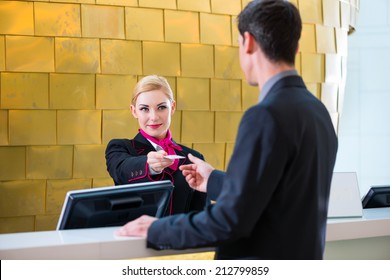 Man In Hotel Check In At Reception Or Front Office Being Given Key Card