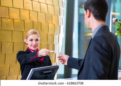 Man In Hotel Check In At Reception Or Front Office Being Given Key Card