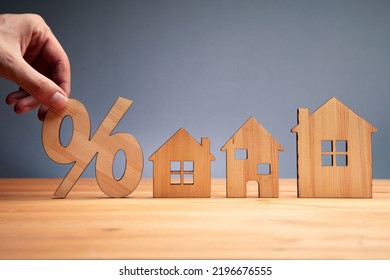 Man With House Model And Percent Sign. Real Estate And Mortgage Interest Rates Concept