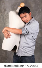 A man hugging a dummy.