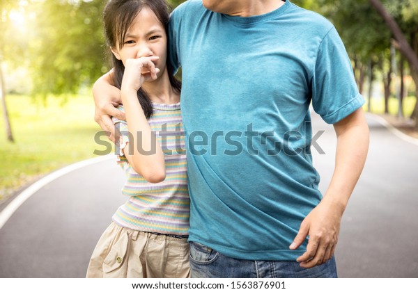 Man was hugging her daughter while her child girl\
can smell the armpit smelly or the body odor foul from her father\
with closing her nose,feel stinks,asian male people smell and sweat\
from hot weather