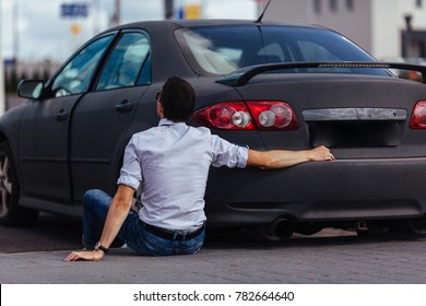 A Man Is Hugging His Car