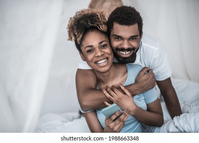 Man hugging his wife in morning in bedroom - Shutterstock ID 1988663348