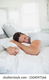 Man Hugging Pillow On Bed