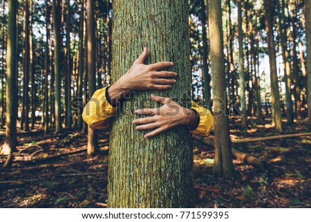 Man hugging tree bark